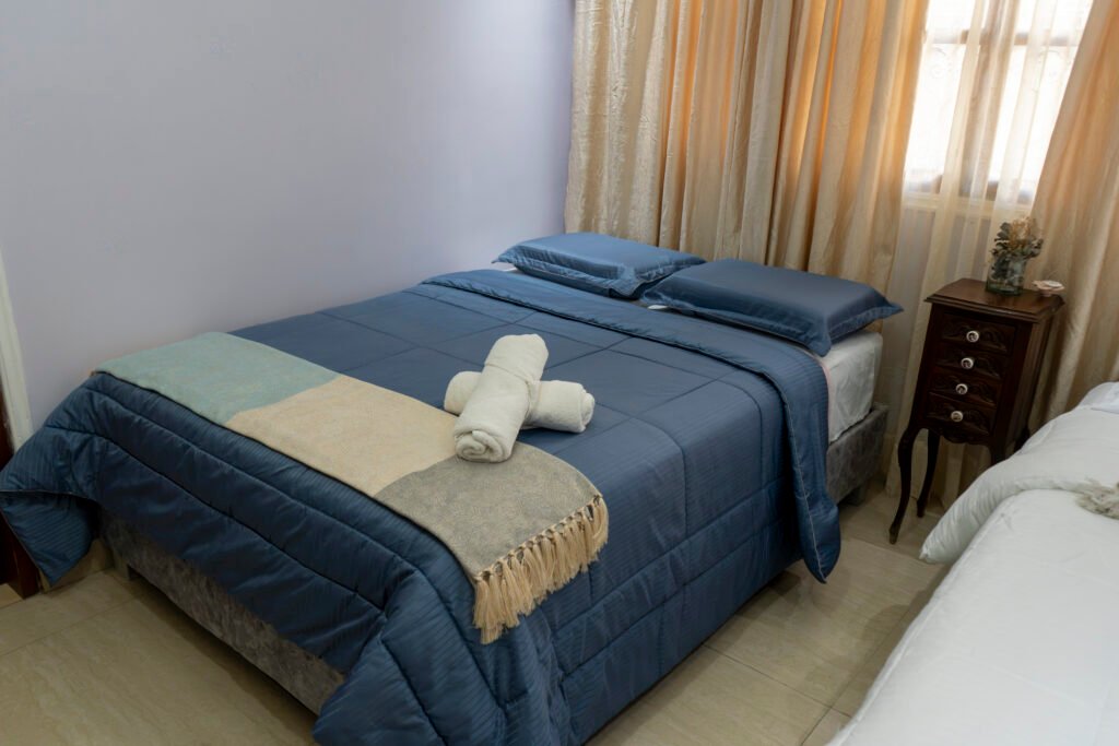 Cama principal de la habitación Caribe con cobertor azul