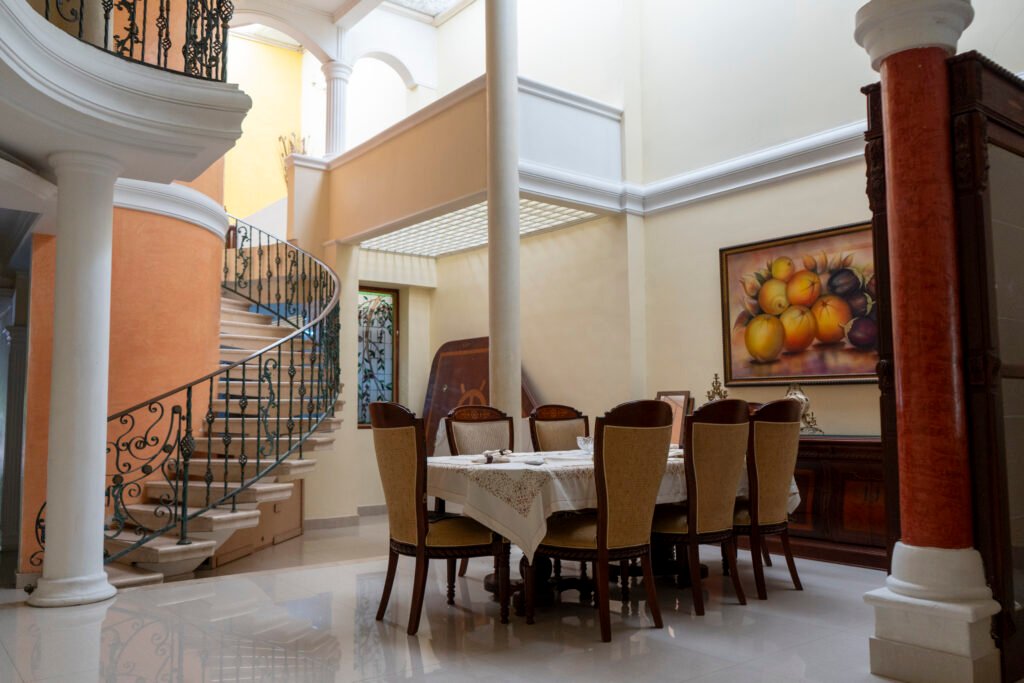 Comedor de doble altura junto a la escalera de hierro forjado