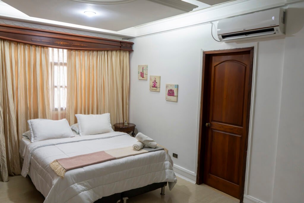Habitación Jazmín con cama doble y cortinas doradas
