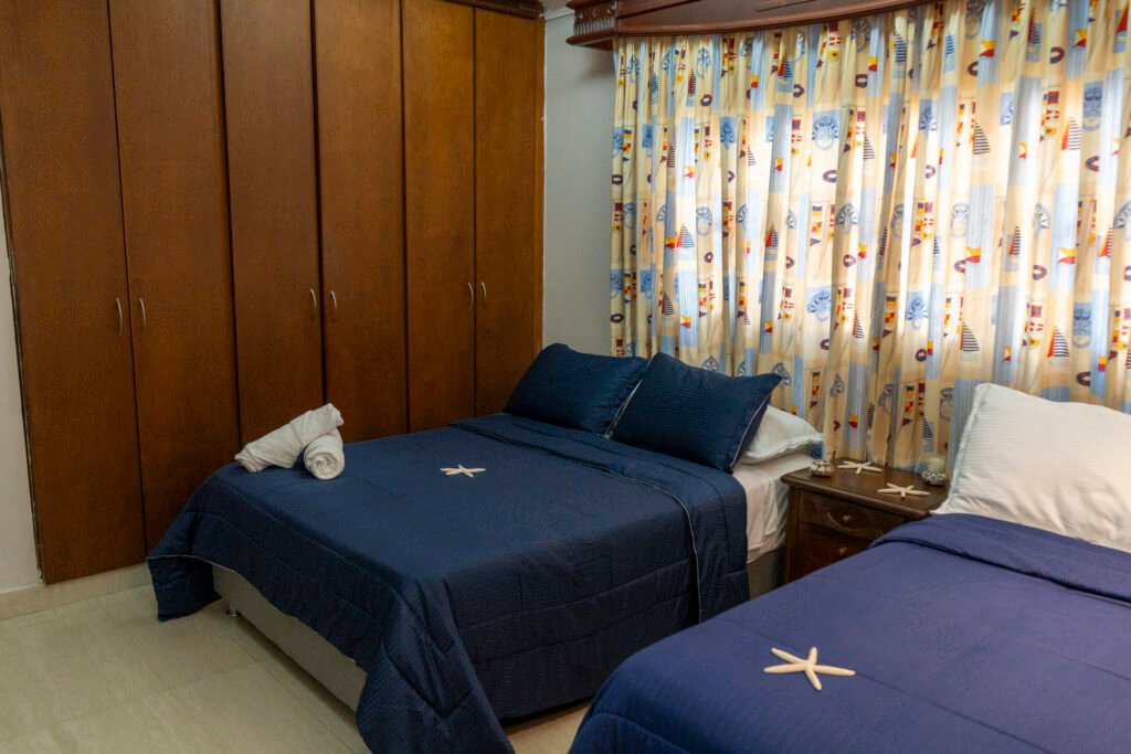 Habitación Bahía con clóset de madera y dos camas