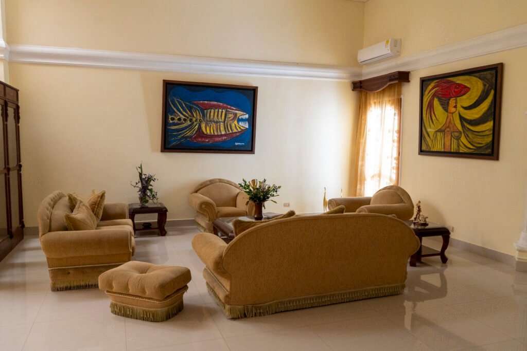 Sala con sofás dorados y cuadros de colores