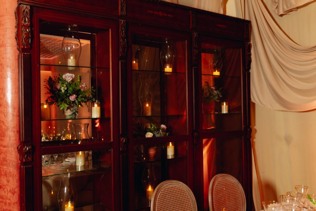 Vitrina de madera iluminada con velas junto al salón