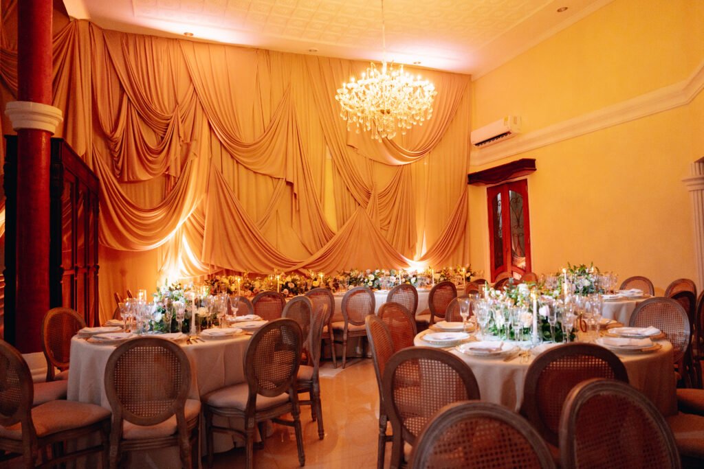Salón con mesas redondas y candelabro de cristal