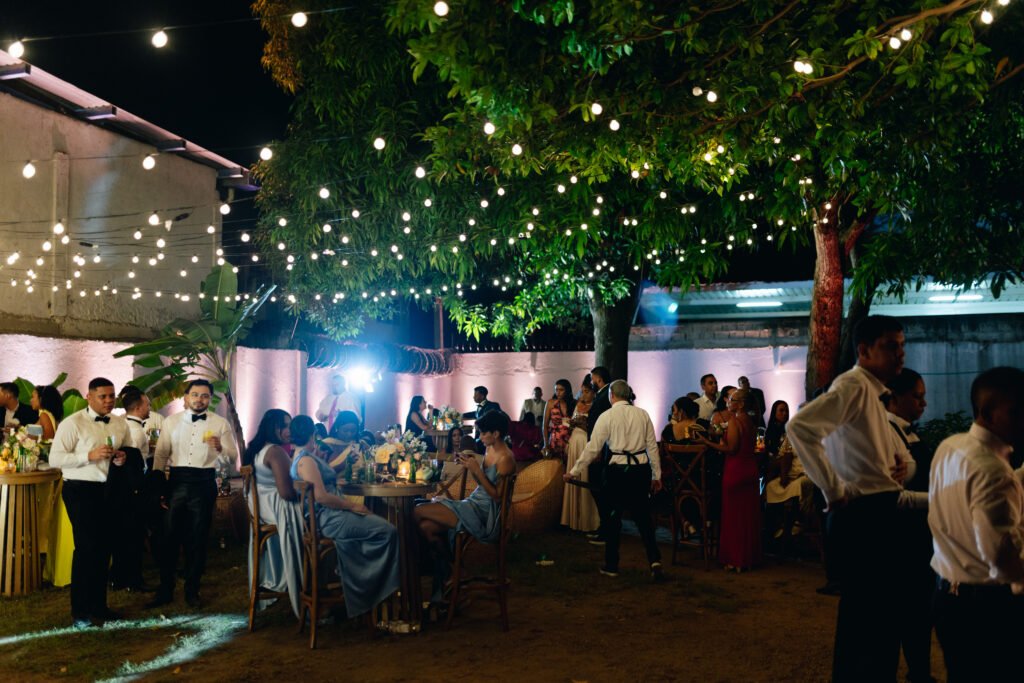 Invitados en el patio bajo los árboles iluminados