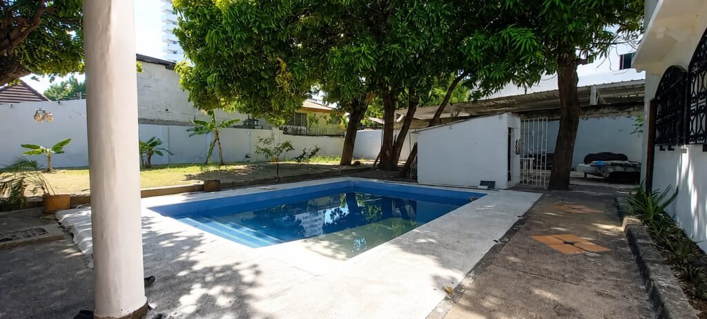 Piscina del patio vista desde el corredor, bajo la sombra de los árboles